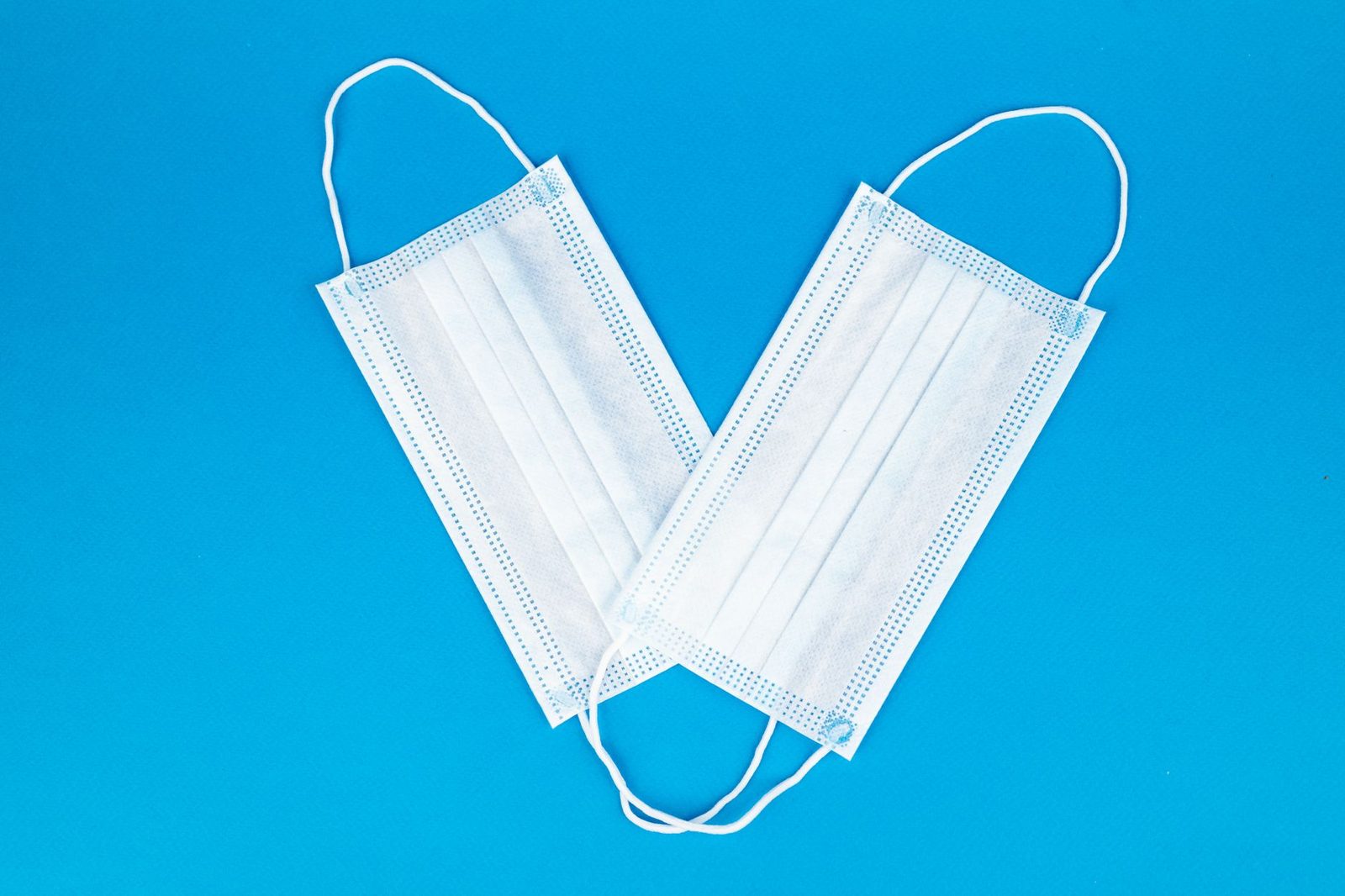Two protective face masks on a blue background, emphasizing health and safety.