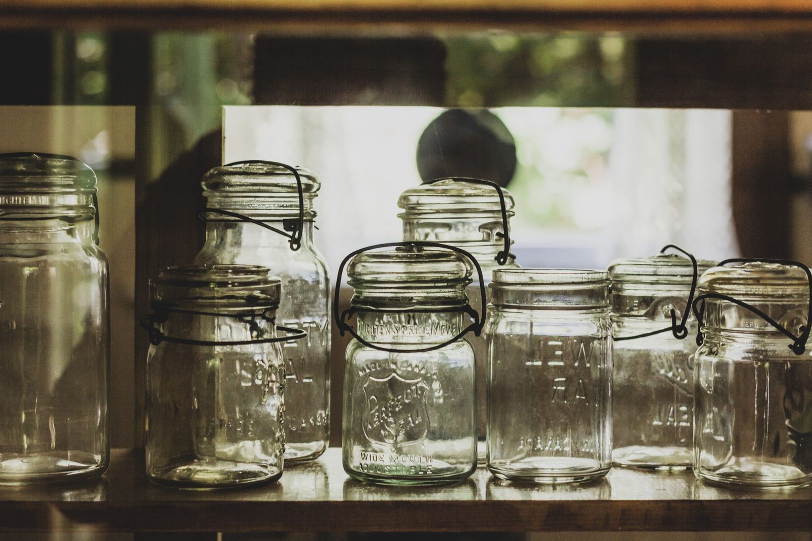 Collection of vintage mason jars on a shelf, showcasing rustic charm.