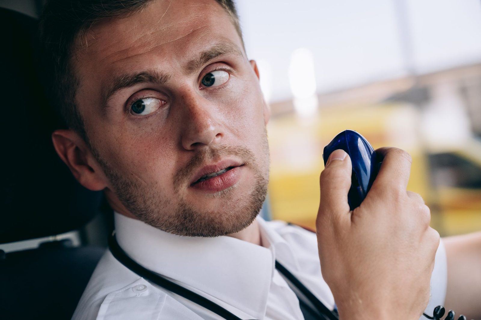 Close-up of a security officer attentively listening to a two-way radio.