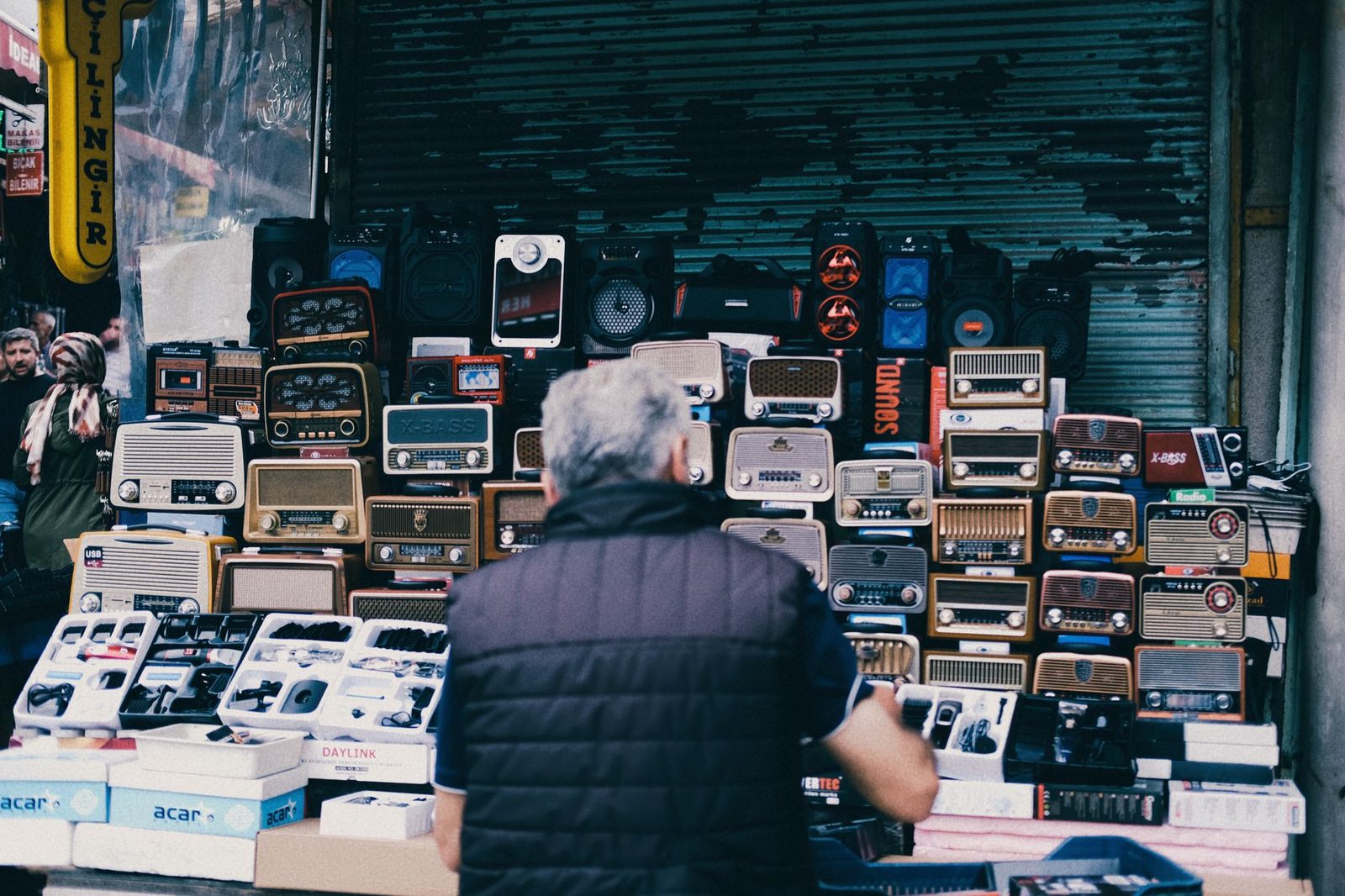 A bustling urban street market stall featuring a collection of vintage radios and electronics.