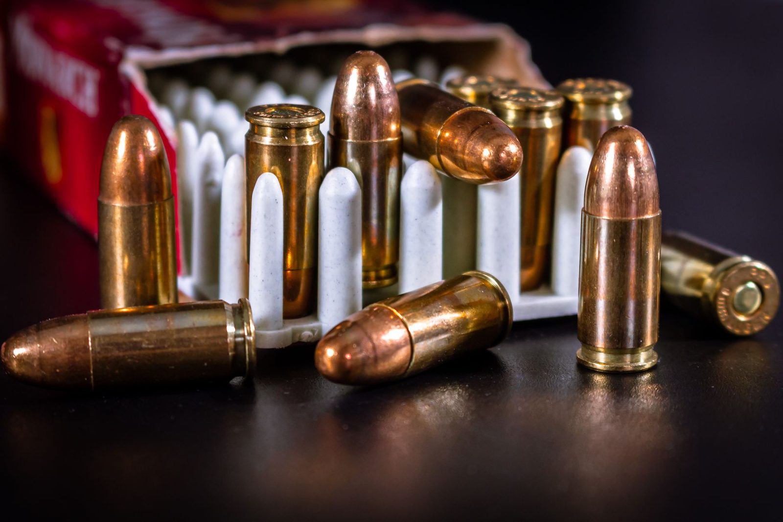 Detailed image of bullets and ammo in a container showcasing copper casing and ammunition close-up.