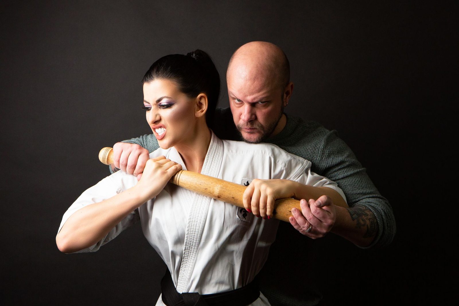 Martial arts training session showing self-defense techniques with a wooden stick.