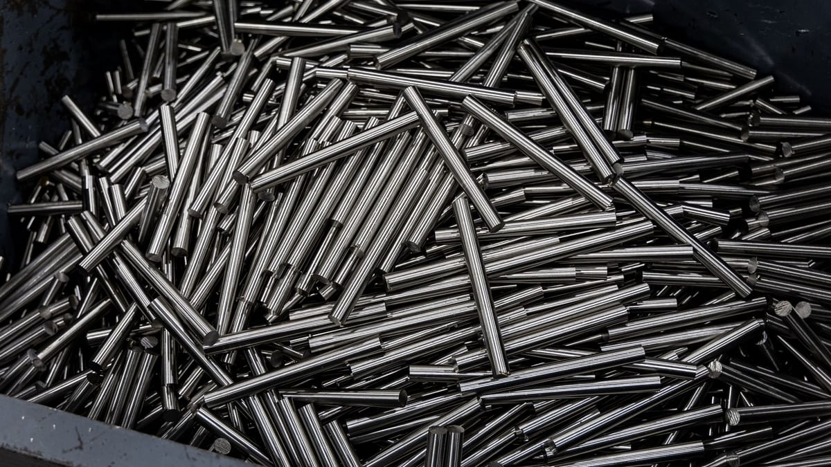Close-up of numerous stainless steel rods in a container, showcasing industrial metal texture.