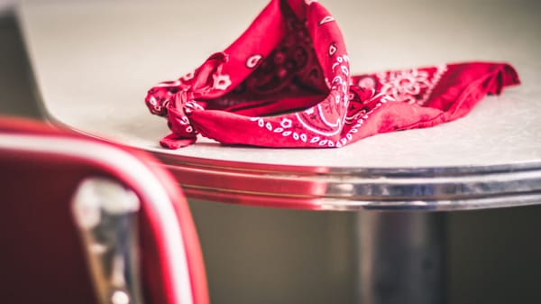 A red bandana rests on a classic diner table, evoking nostalgia and vintage style.