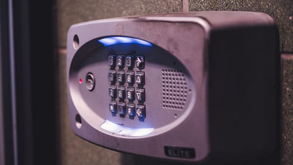 A close-up image of an illuminated security keypad mounted on a wall.
