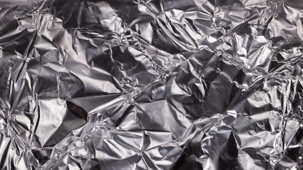 Close-up of shiny crumpled aluminum foil showcasing metallic wrinkled texture.