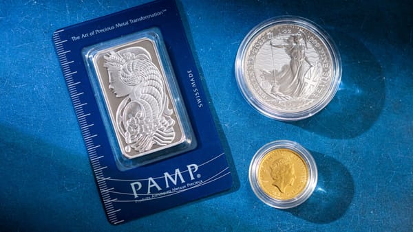Silver bar and coins on blue surface, highlighting investment and collectible value.