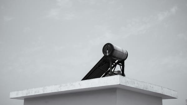 Solar water heater on a rooftop against a clear sky, energy efficient design.