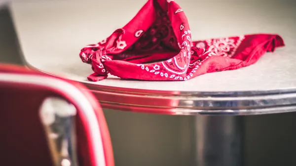 A red bandana rests on a classic diner table, evoking nostalgia and vintage style.