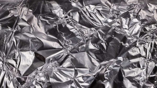 Close-up of shiny crumpled aluminum foil showcasing metallic wrinkled texture.