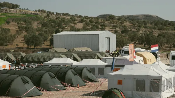 Aerial view of a temporary shelter camp in Antakya, Hatay, Türkiye, surrounded by olive trees.