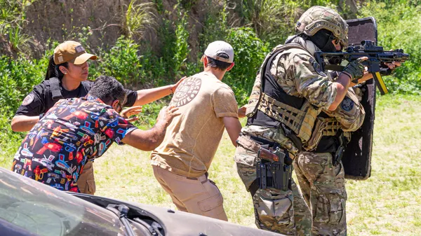 Military personnel in outdoor exercise, showcasing tactical and defensive skills with civilians.