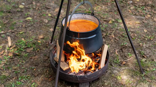 A black pot over a campfire cooking food outdoors in Garešnica, Croatia.