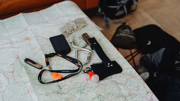 A collection of travel tools and gear laid out on a map, ready for an outdoor adventure.