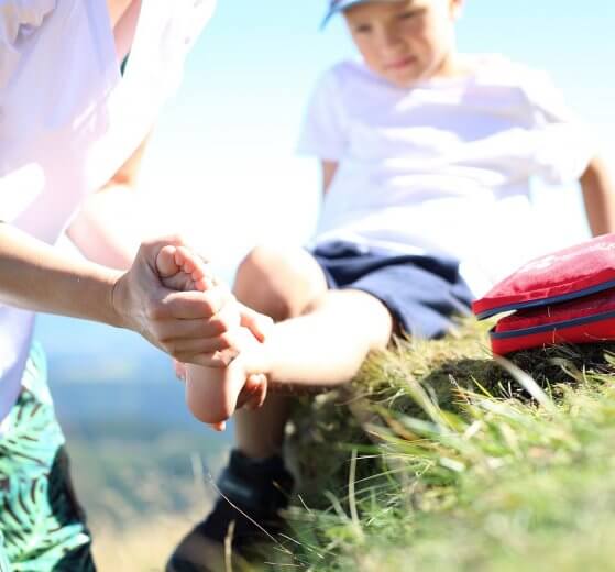 boy with sprained ankle getting first aid
