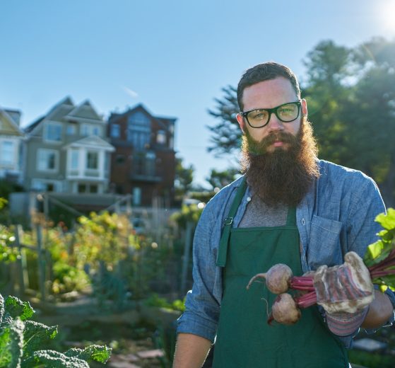 urban prepper showing off his garden produce